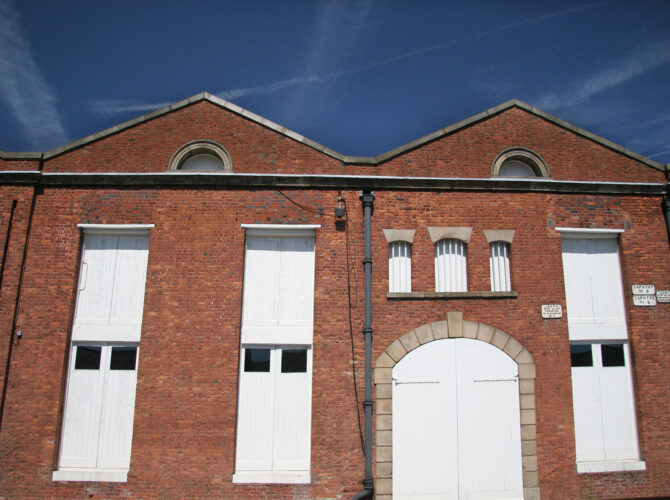Front-facing view showing the strong symmetry of the building, with large central doors for moving goods in and out.