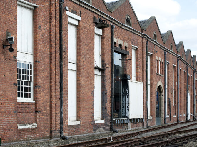 Trackside view of the 1830 Warehouse showing tall loading bays, timber doors and iron hoist used for lifting goods directly from rail wagons.