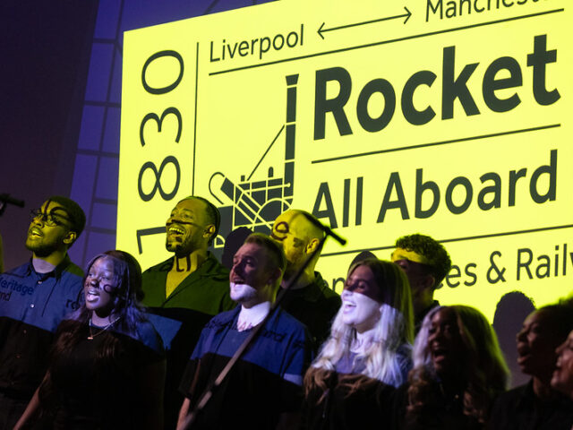 An image of mainly young people singing in front of a Rocket logo