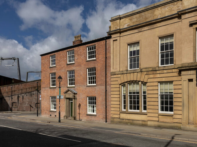 Street view showing the Georgian brick Station Master’s House alongside the classical stone station buildings of the former Liverpool Road Railway Station.
