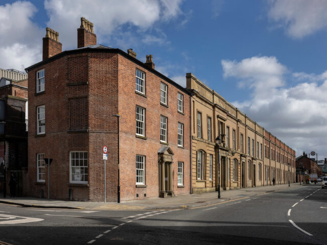 Red-brick Station Master’s House and long sandstone terrace of early Lime Street station buildings on Lime Street, Liverpool.