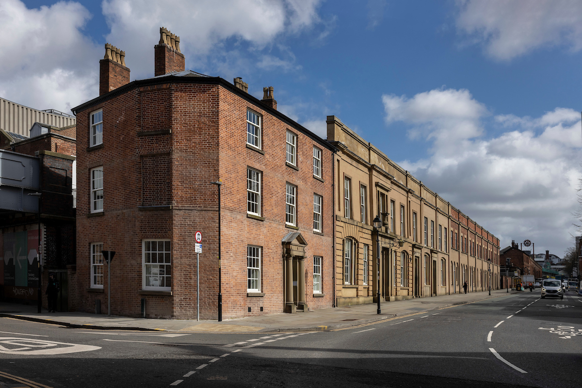 Red-brick Station Master’s House and long sandstone terrace of early Lime Street station buildings on Lime Street, Liverpool.