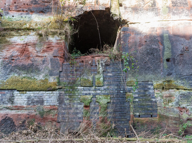 Partly bricked-up opening in the sandstone wall at Edge Hill.