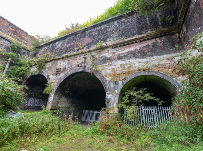Three brick arches of the Edge Hill Engine Station in an overgrown cutting