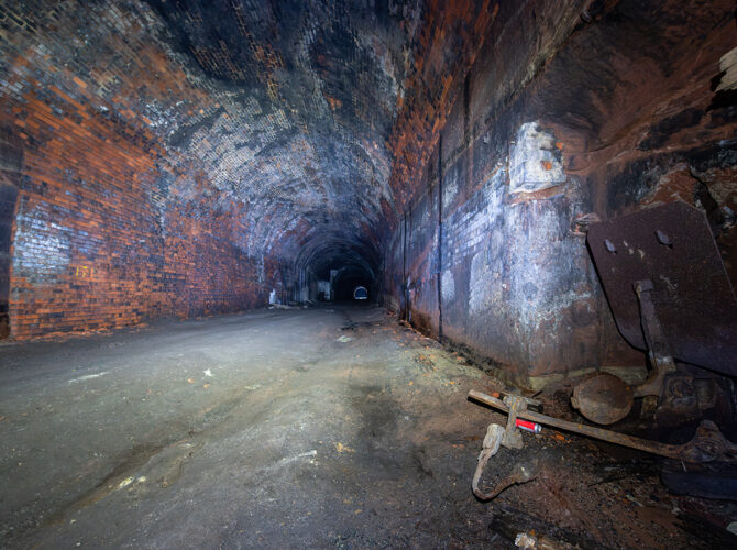 Inside the Wapping Tunnel showing worn brickwork, damp walls and remnants of historic railway infrastructure