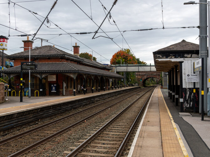View along both platforms showing historic station architecture and a footbridge overhead.
