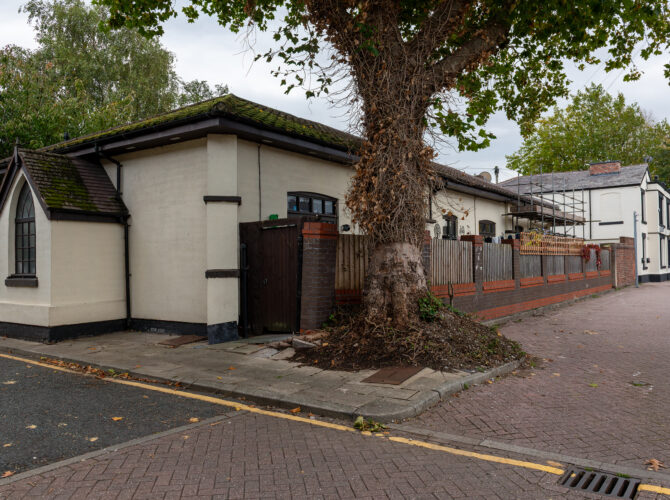 Side view of one of the village buildings next to later housing