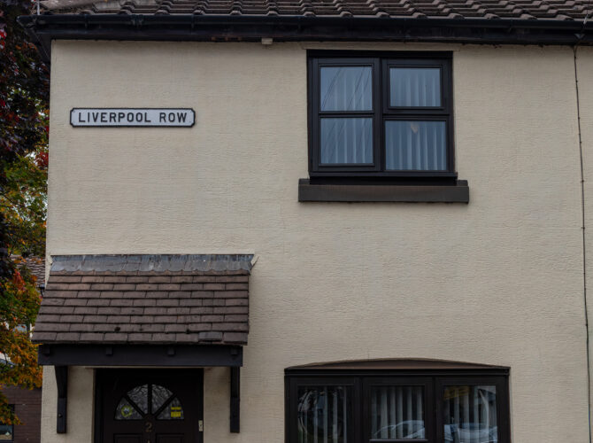 End terrace cottage showing one of the historic street names in the village with Liverpool Row street sign.