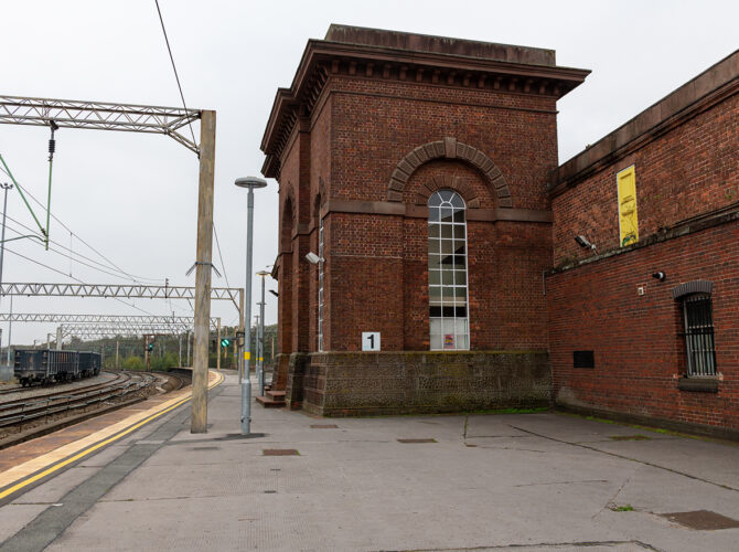 Detailed view of the tall brick accumulator tower with arched window and decorative brickwork, part of the station’s hydraulic system.