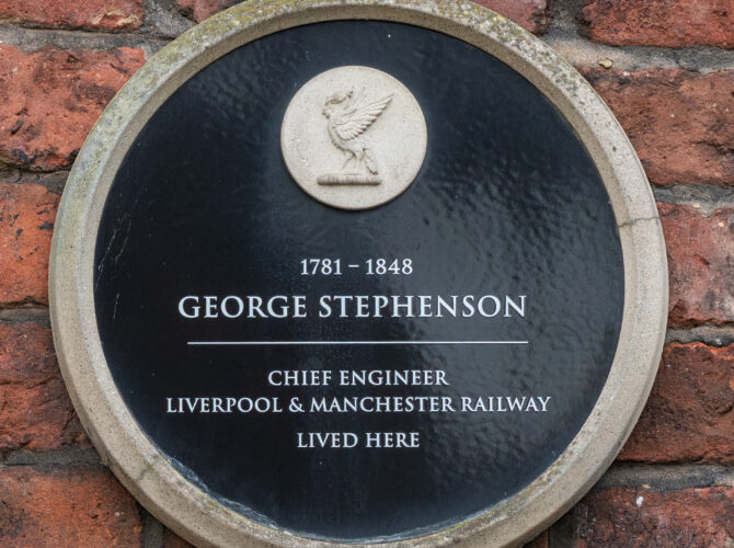 A round plaque set into a brick wall commemorates George Stephenson and notes that he lived here.