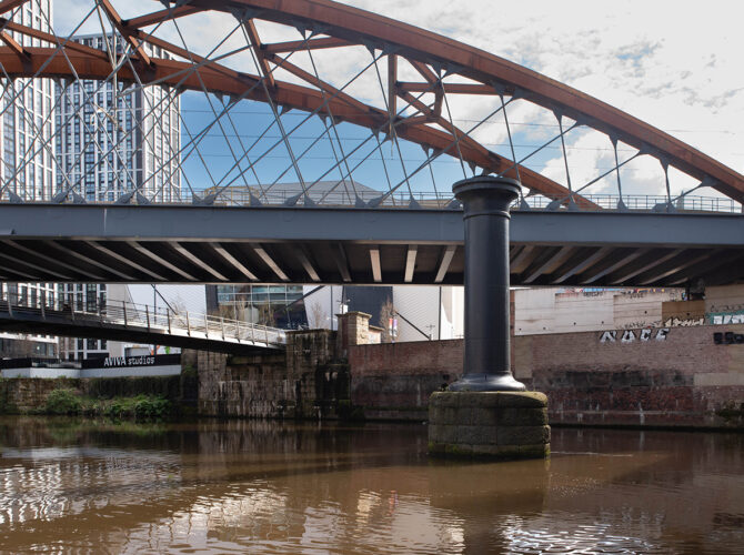 Close view of a later iron bridge crossing above the water near the historic railway route.