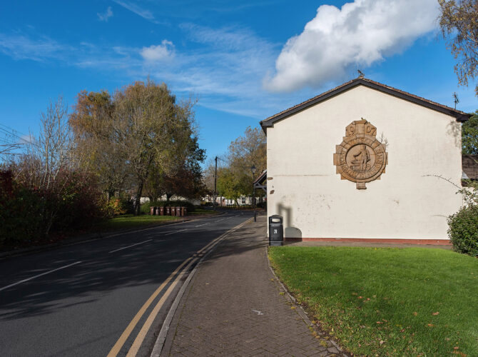 The Vulcan Foundry crest is displayed prominently on a gable wall within the village