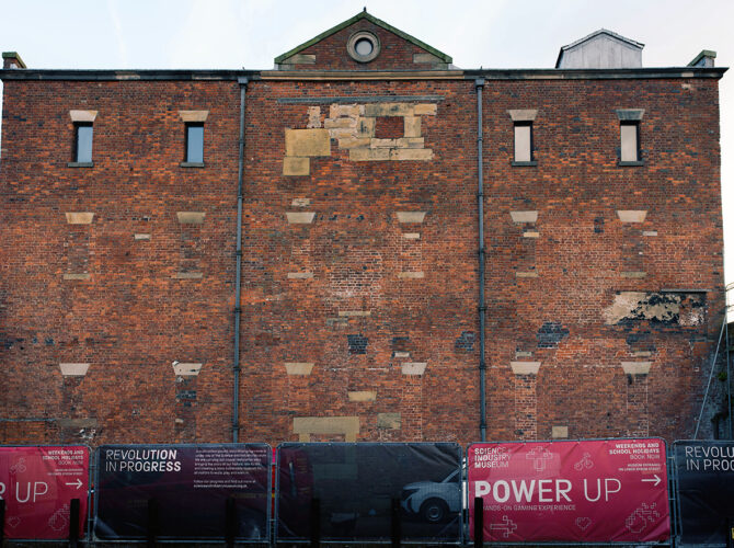 View of the gable end of the former Liverpool Road warehouse, showing patchwork brickwork and blocked openings reflecting its long industrial history.