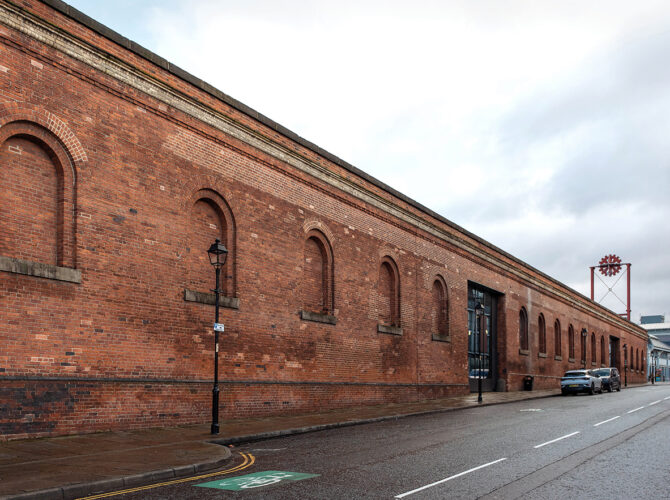 Long red-brick industrial building with arched window recesses, now housing the Power Hall at the Science and Industry Museum.