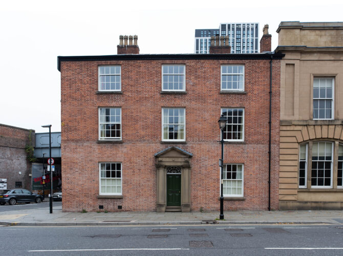 Symmetrical façade of the brick Station Master’s House with central doorway and sash windows facing Liverpool Road.