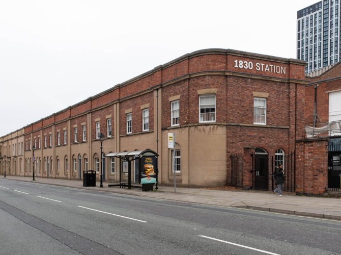 Perspective view of the historic station structure, now part of the museum complex, with signage marking “1830 Station.”