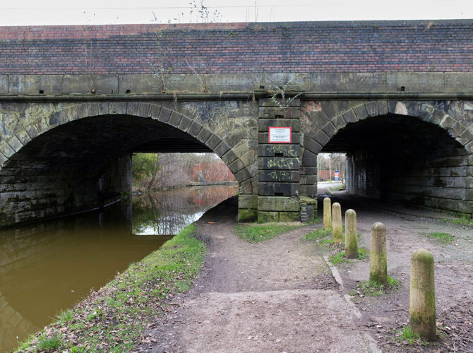 Bridge showing separate arches for water and pedestrians beneath the railway.
