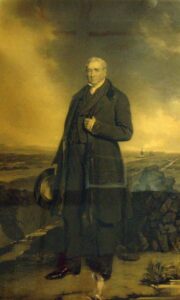 portrait of George Stephenson standing on Chat Moss. A gentleman standing in old clothes and a hat in hand against a backdrop of countryside