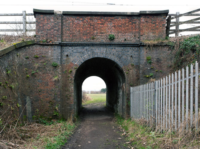 The front of the bridge highlights the carefully laid brick arch and weathered masonry.