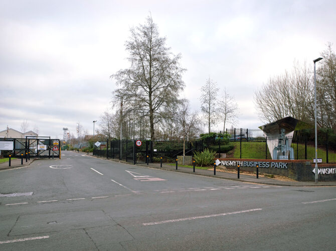 The business park entrance on Green Lane, with signage and the steam hammer visible behind railings.