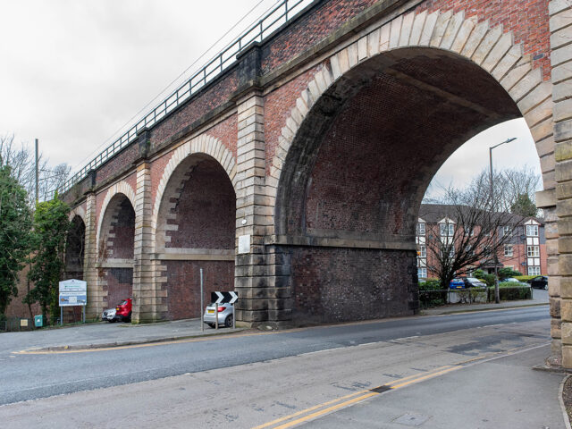Side view of a main arch spanning the road, showing the scale of the structure and surrounding street.