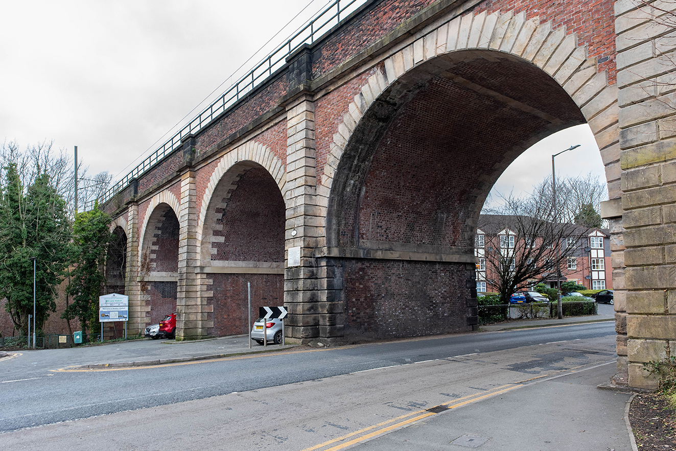 Side view of a main arch spanning the road, showing the scale of the structure and surrounding street.