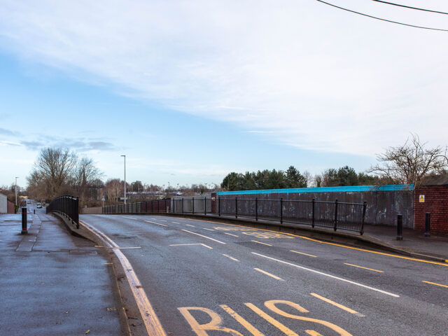 Perspective view along the bridge showing its curve and the landscape beyond.
