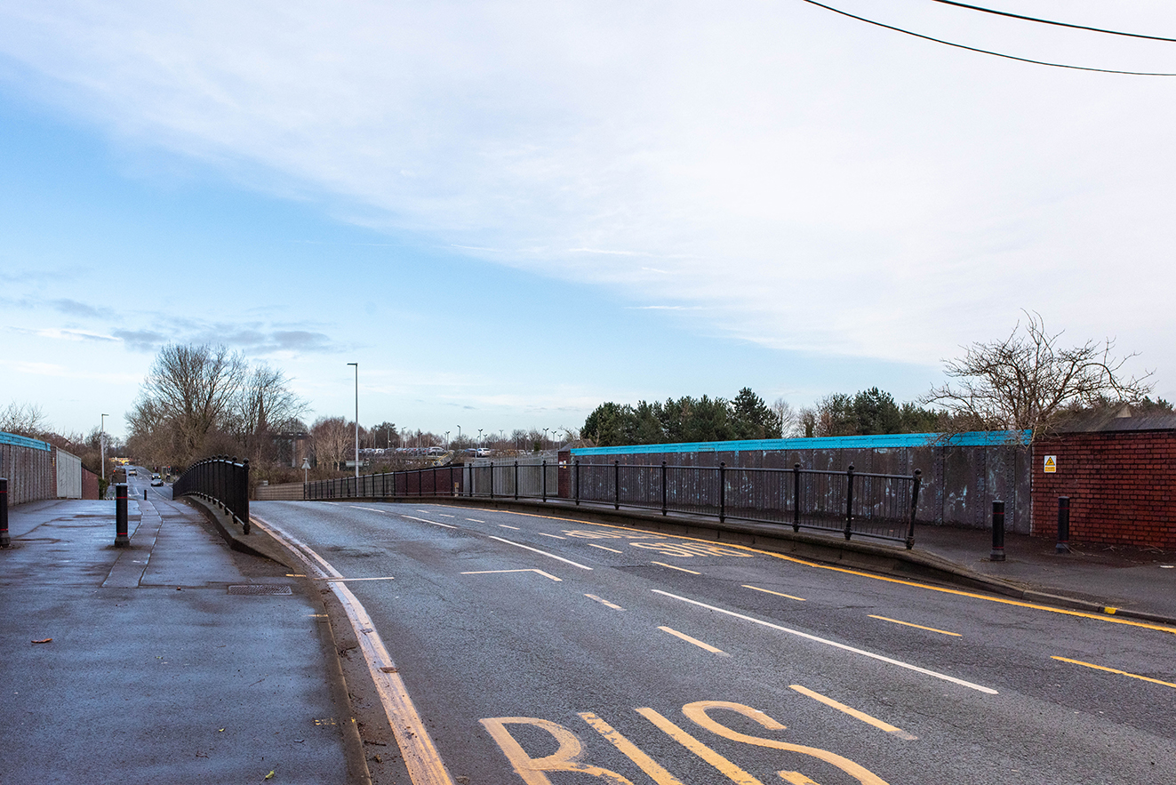 Perspective view along the bridge showing its curve and the landscape beyond.