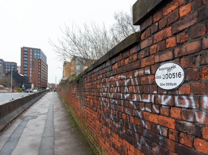 Close view of brick wall with a circular railway identification plate