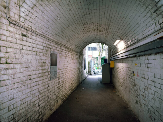 The arched brick underpass beneath the railway, linking the station entrance to the platforms.