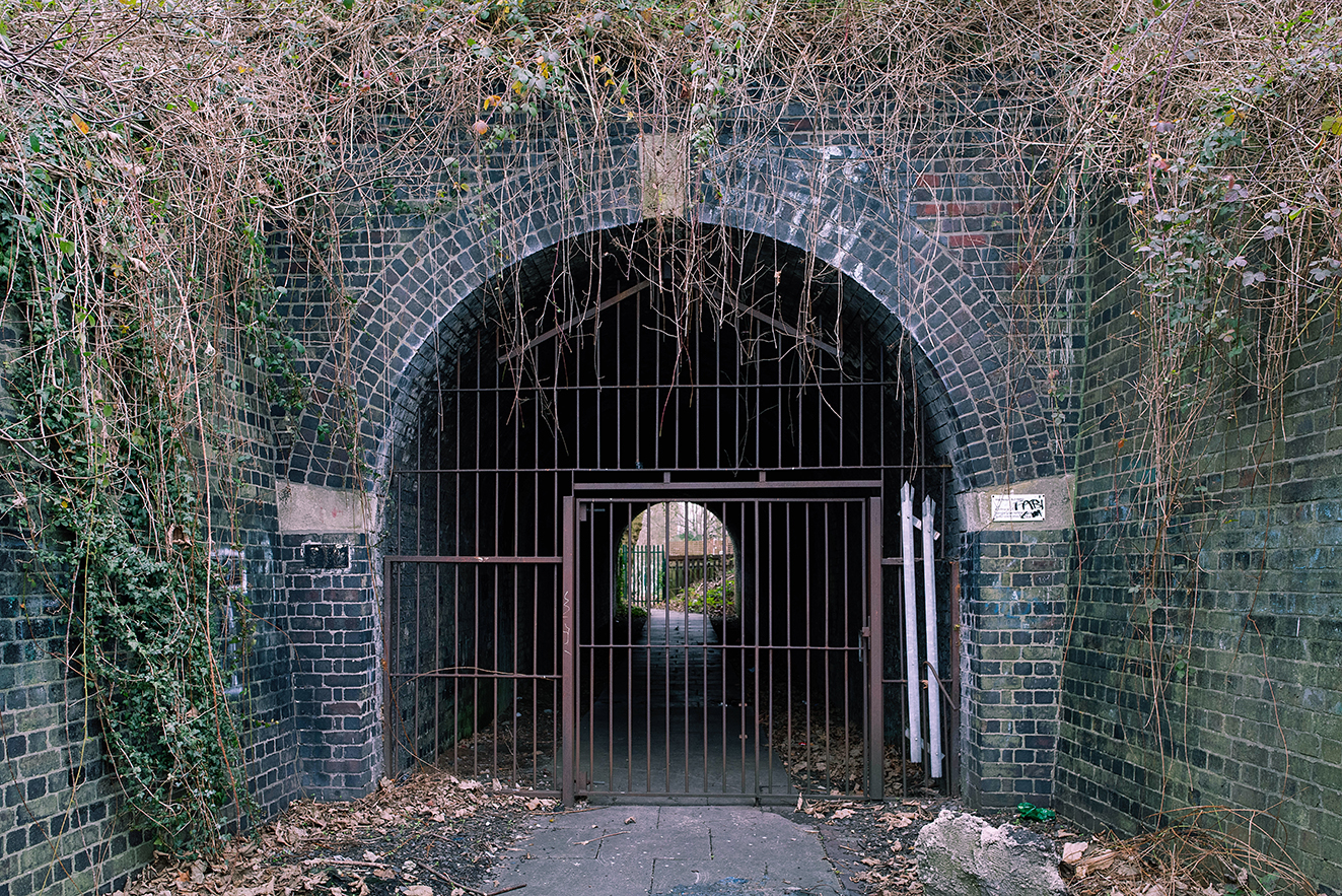 A detailed look at the tunnel entrance, highlighting the curved brick arch and weathered masonry.
