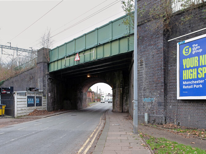 The bridge seen from the pavement, highlighting the contrast between original brickwork and later steel additions.