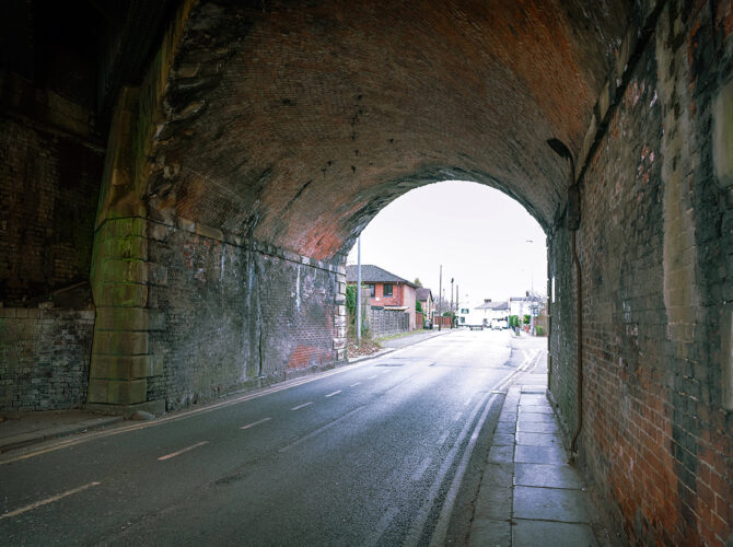 The curved brick interior of the arch frames the road, with weathered surfaces from years of passing traffic and steam.