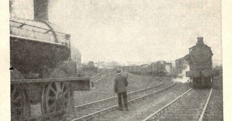 A grainy image of a lone man between two loco trains
