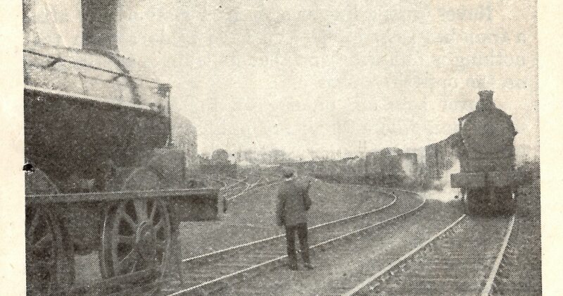 A grainy image of a lone man between two loco trains